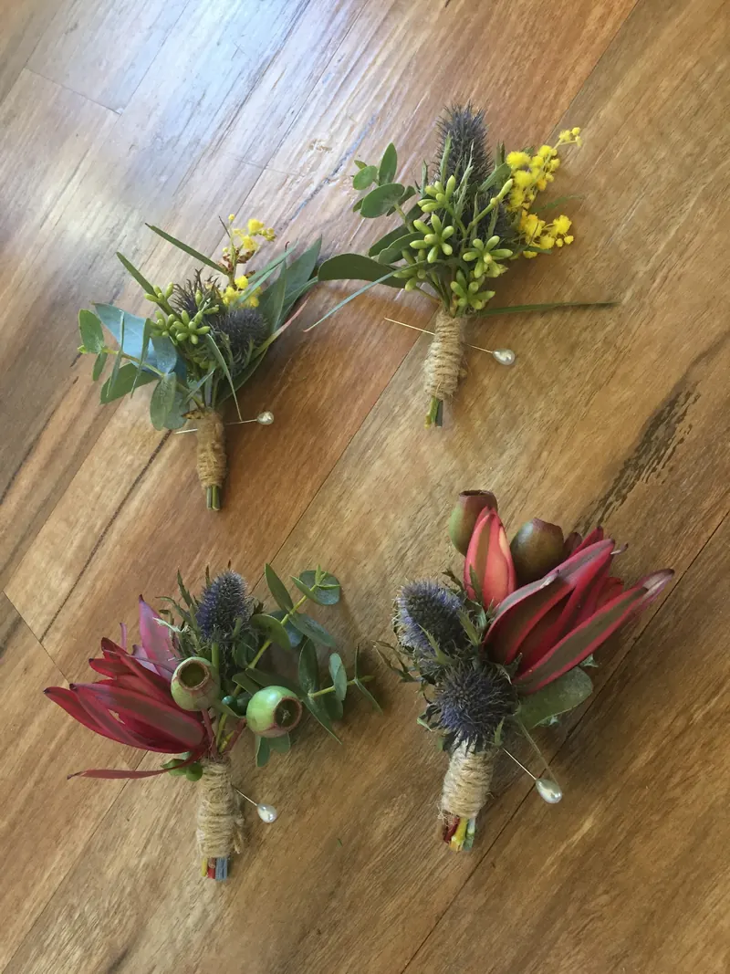 Native buttonholes tied with twine, with thistle, wattle and protea
