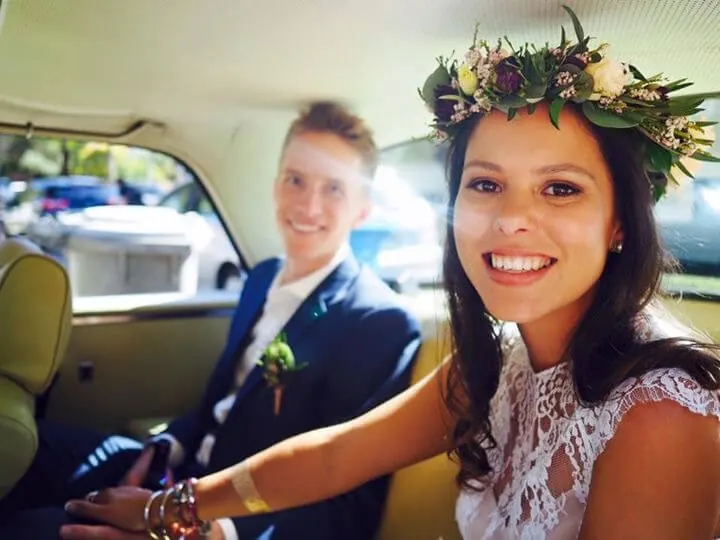 A smiling bride wearing a flower crown of natives and garden flowers